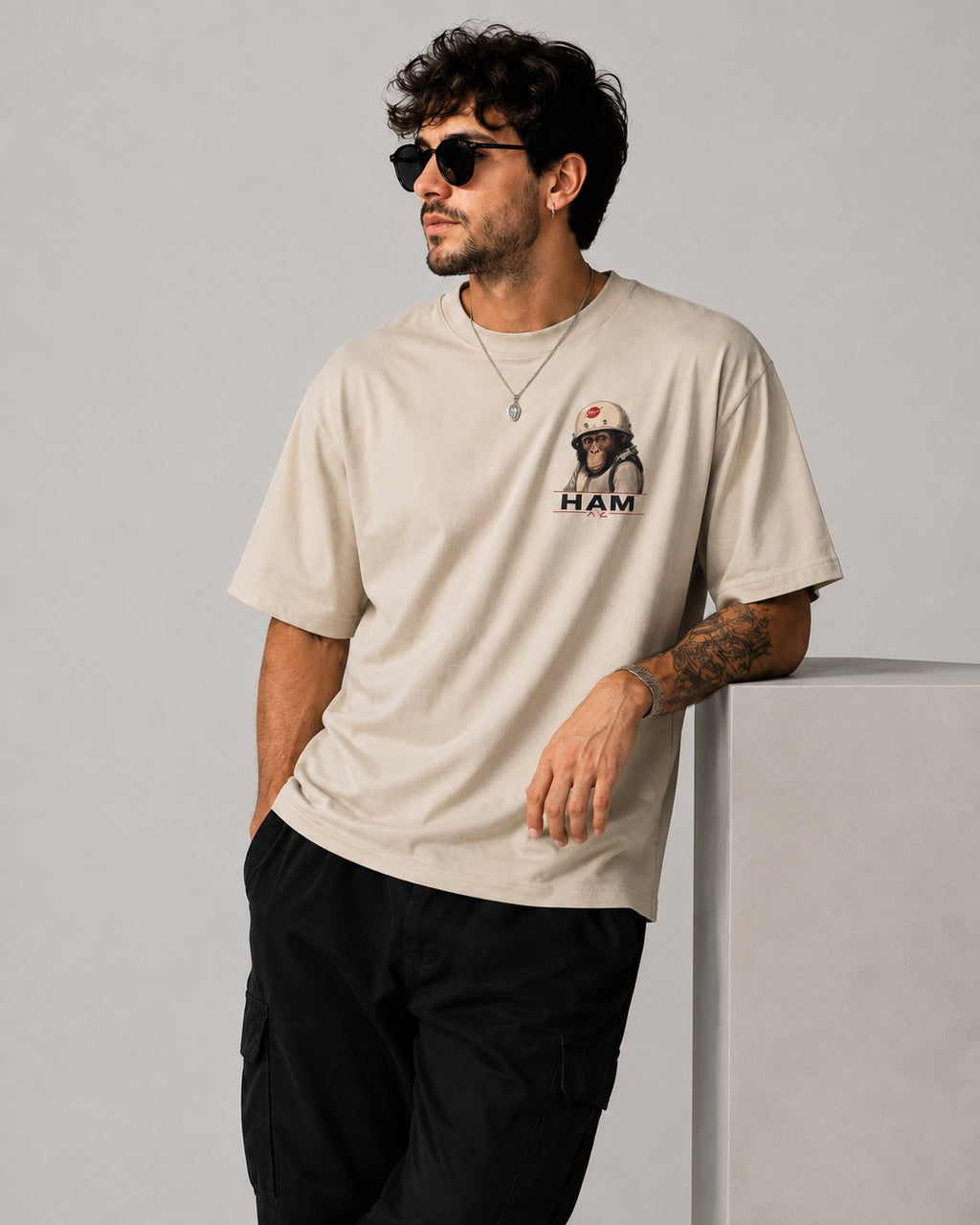 Homme portant le t-shirt oversize beige HAM le singe astronaute avec imprimé poitrine