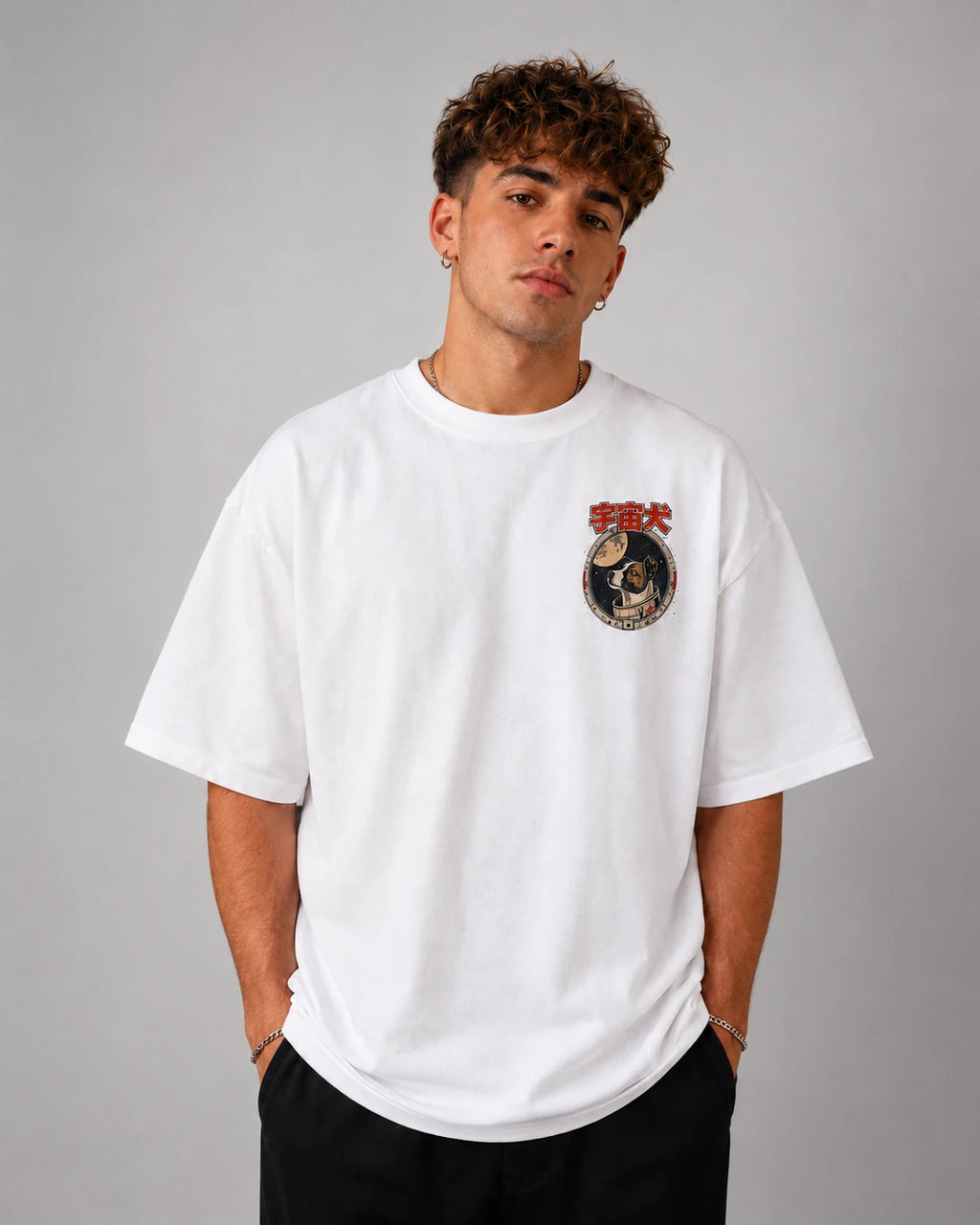 Homme portant de face le t-shirt oversize blanc Laïka Benkei Studio, badge de mission sur la poitrine