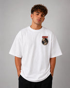 Homme portant de face le t-shirt oversize blanc Laïka Benkei Studio, badge de mission sur la poitrine